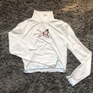 silky, white turtleneck with unique butterfly.